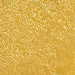 Gold paint on  rough cement wall texture. gold background