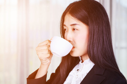 business woman in suit drinking coffee or tea cup