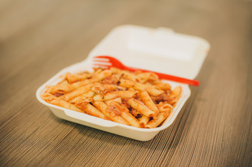Pasta and spaghetti in delivery package with plastic fork