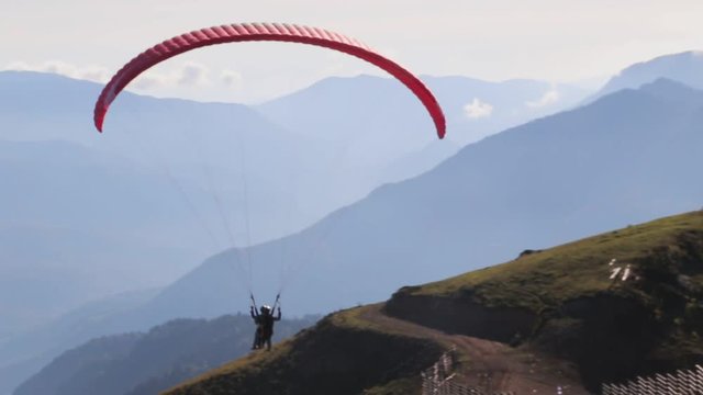 A paragliding soaring along a ridge line gains lift.
