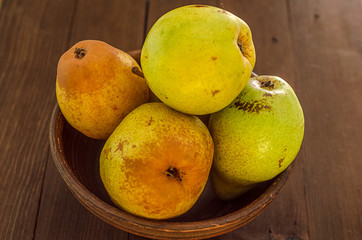 Pears. Pears harvest. Fresh organic pears in clay plate with autumn leaves on wooden table. Pear autumn harvest. Autumn nature concept.Selective focus.Top view