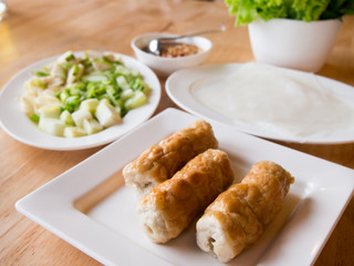 Vietnamese food called "Nam neaung" that is Pork Sausage and salad on white dish and bowl background