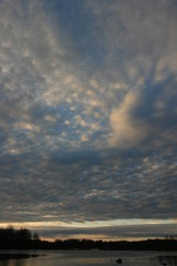 Cloudy sky on the forest lake in the autumn.