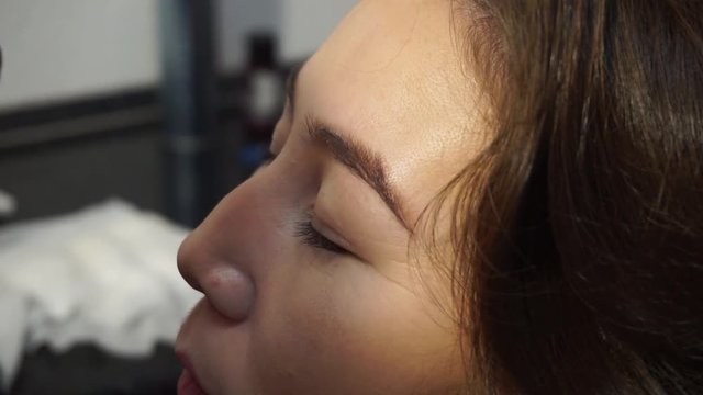 Eyebrow correction. The stylist plucks the eyebrows of an adult woman, corrects the shape of the eyebrows. Facial care