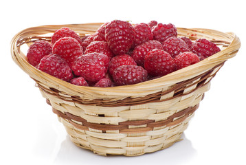 ripe raspberries in basket with mint on white
