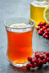 Hot spiced orange tea with honey and berries on dark concrete background. Selective focus, close up, copy space.