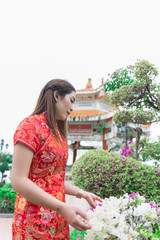 happy Chinese new year. Asian woman wearing traditional Cheongsam clothes portrait outdoor