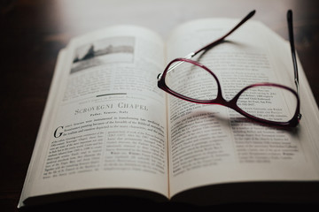 Red glasses sitting on book