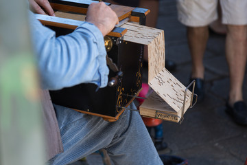 Street Musician plays Wooden Barrel Organ with Perforated Cardbo