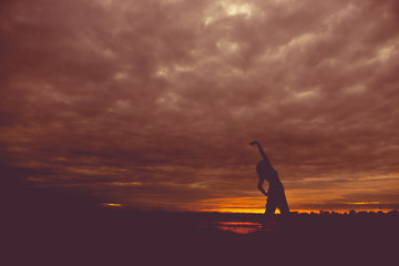 Silhouette of asian woman play yoga on sunset