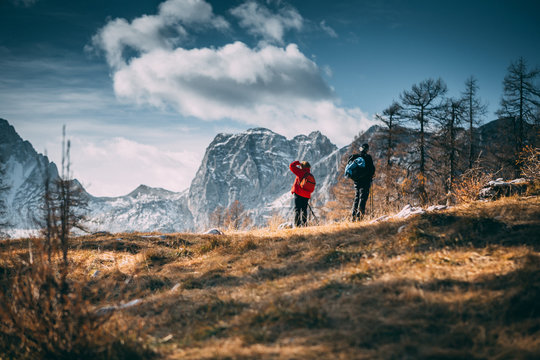 Group of hikers with backpack hiking along a trail towards mountain pass in Julian Alps, lifestyle outdoors