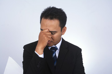 Asian young businessman headache pinching his nose