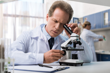 Chemist working with microscope