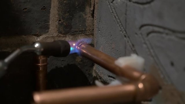 Blow torch brazing solder on copper water pipe elbow fittings England May 2017