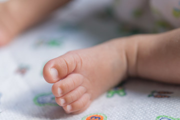 Closeup foot of asian baby on the bed