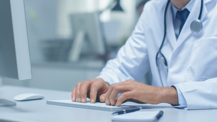 Close-up shot of Senior Doctors Hands Using Keyboard Typing a Message.