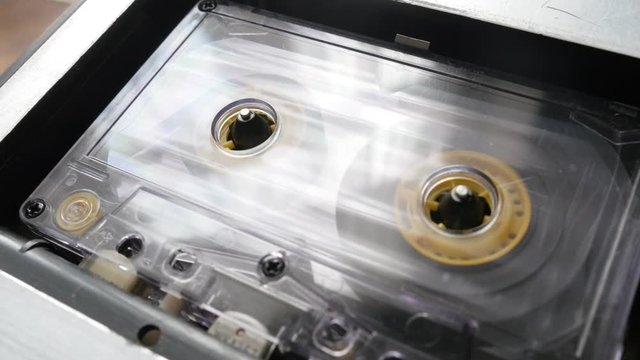 Rotation of audio tape player supply spindle shallow DOF footage - Retro cassette in casettophone close-up 