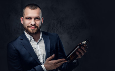 A man dressed in an elegant suit holds craft beer.