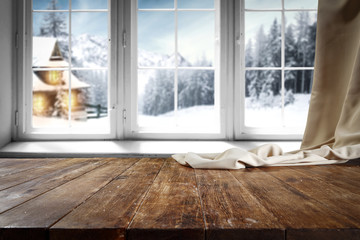 Wooden table with free space for your product or promotional text. Open window with snowfall....