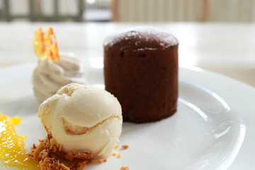 Chocolate lava cake with vanilla ice cream on dish for celebration event.  