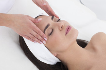 Obraz na płótnie Canvas Beautiful woman in Spa having a facial massage.