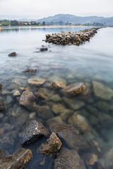 larga exposición de un espigón de roca en mitad de un río