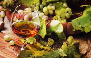 Cognac In Glass, Grapes And Vine, Vintage Wood Background, Selective Focus
