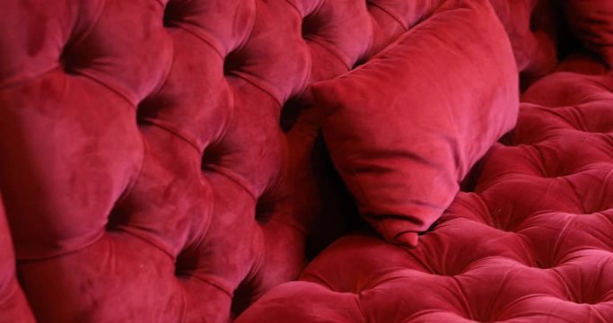 Textured surface of sofa with velour tapestry of red color close-up