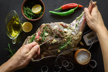 Raw lamb leg, marinated with herbs