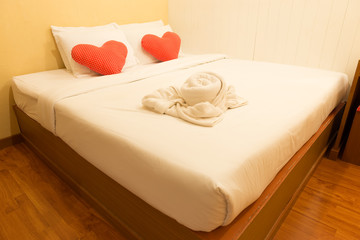 The bed with red pillow heart with bright yellow light in room for valentine night
