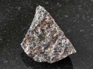 raw spreusteined urtite stone on dark