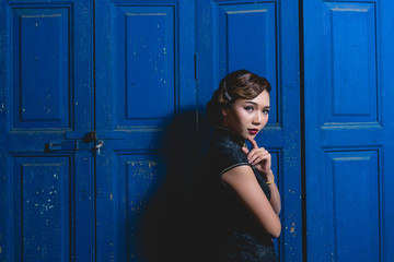 Portrait of asian woman in black dress on wooden door background night scene