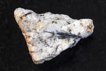 black Ludwigite crystals in raw stone on dark