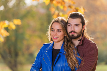 Fototapeta premium Cute couple in park filled with autumn colors.