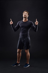 Fototapeta na wymiar Male model in active sportswear against black background with copy space