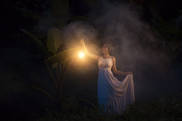 Fantasy beautiful holding lantern light in forest dream
