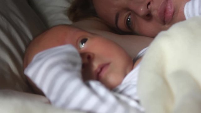 Mother and her Newborn Baby. Happy Mother and Baby kissing and hugging. Resting in bed together. Maternity concept. Parenthood. Motherhood Beautiful Happy Family Stock Video Footage.