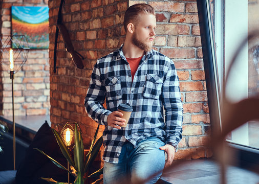 The full body image of blond hipster male drinks coffee.