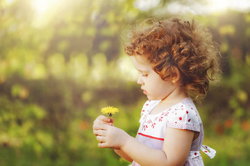 Curly girl with yellow dandelions.