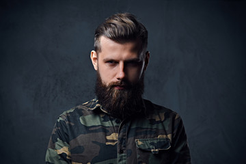 Portrait of bearded tattooed hipster male dressed in a military 