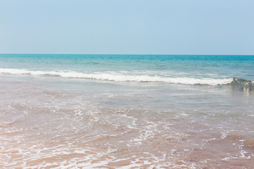 View from a tropical sandy beach on sea turquoise with clear water in clear weather.