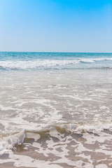 View from a tropical sandy beach on sea turquoise with clear water in clear weather.