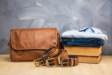 Asian vintage style men clothing and jeans and bag put on wooden table and loft concrete wall texture background.