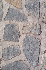 Old stone wall. Uneven rough stones of different shapes. Stone background.