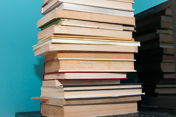 A bunch of books on the laptop.