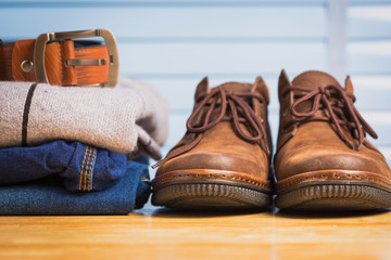 Men clothing asian style vintage with blue jeans pant and leather shoes in modern room with wooden table.