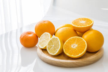 Mandarin oranges and half slice on wooden tray in modern room.