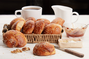 Hot coffee with buns, butter and jam