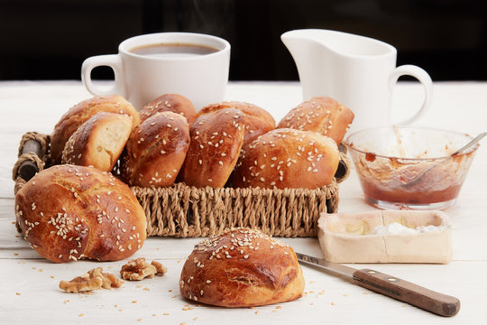 Hot coffee with buns, butter and jam