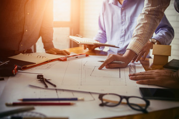 Consultation between colleagues, engineering team to check the blueprint used to build commercial buildings for joint ventures.